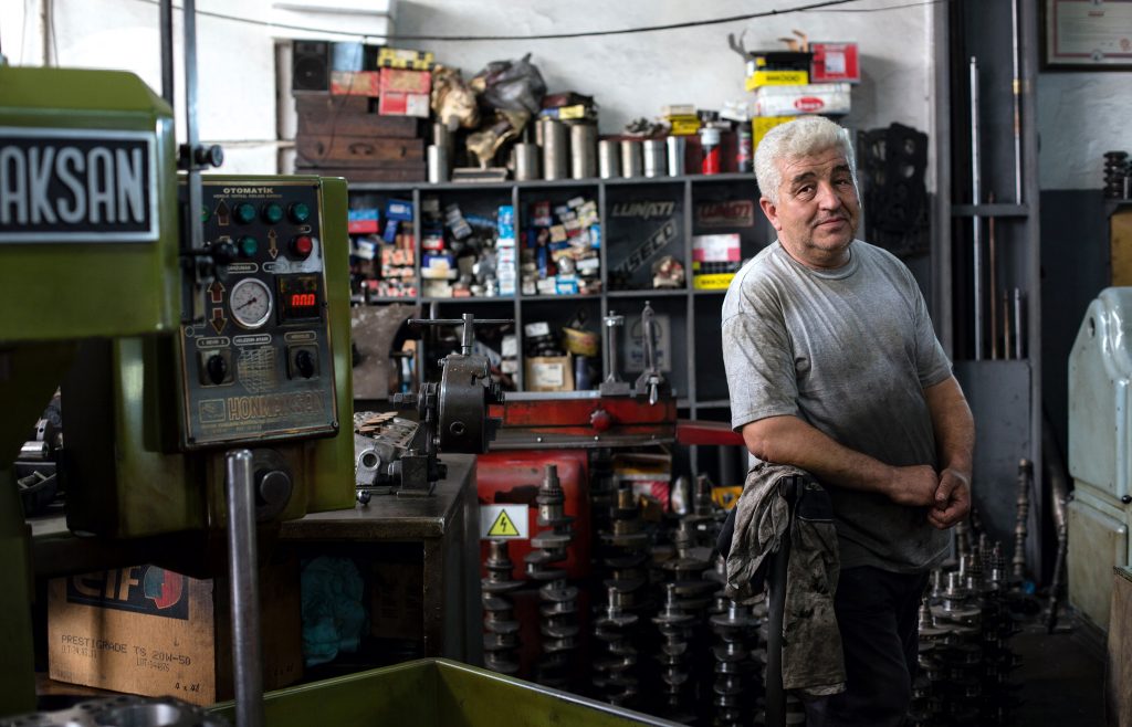 man in gray shirt standing in workshop