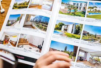 person reading ads with real estate marketing images