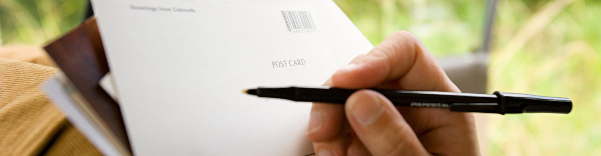 a hand preparing materials for postcard marketing